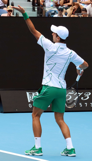Novak Djokovic serving a tennis ball on court