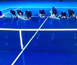 ballkids wiping down blue tennis court