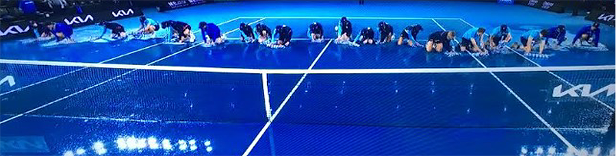 ballkids wiping down blue tennis court